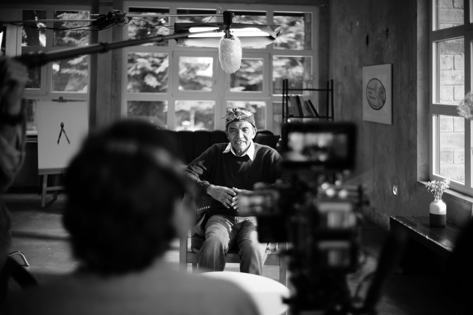 Interview subject on camera, boom mic overhead