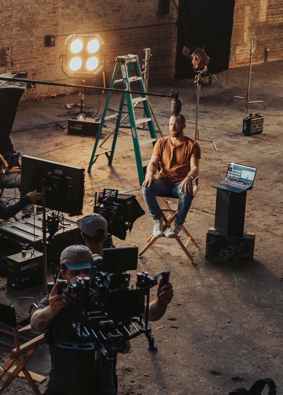 Interview subject in a studio, crew and monitors around